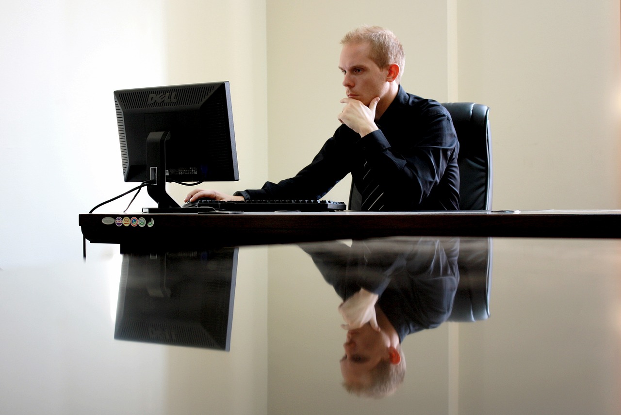 A person thinking while working on a laptop