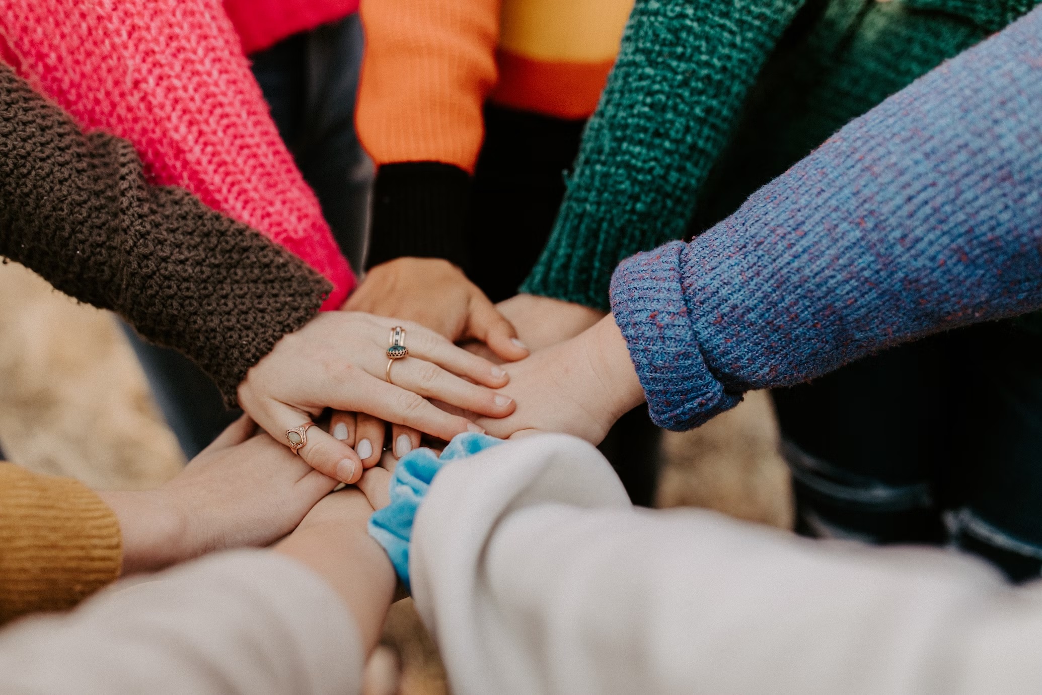 A close-up of people joining hands.