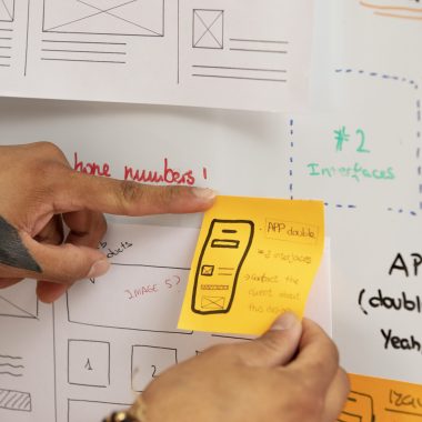 high-angle-hands-holding-post-its